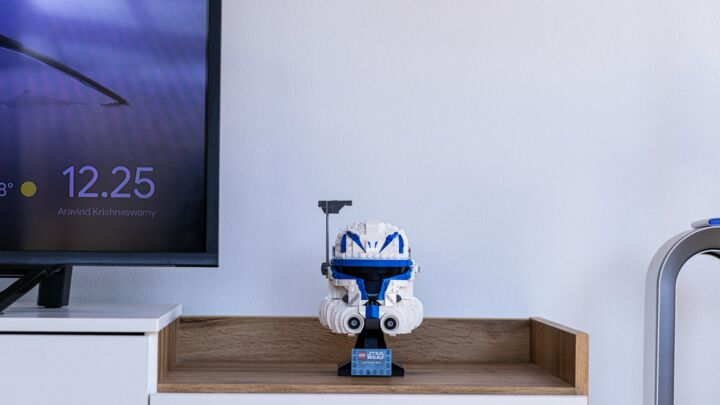 a robot toy sitting on top of a wooden shelf