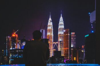 man standing near Petronas Tower