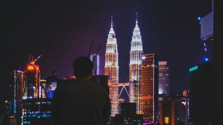 man standing near Petronas Tower