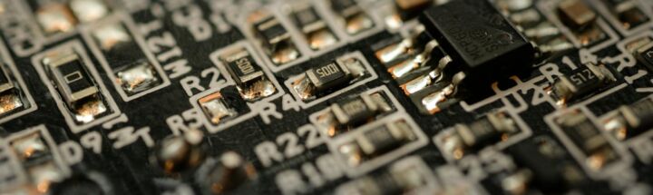 Detailed close-up of a microchip on an electronic circuit board with components and connections.