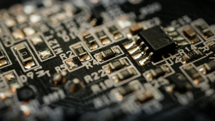 Detailed close-up of a microchip on an electronic circuit board with components and connections.
