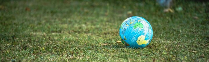 blue and white desk globe on green grass field during daytime