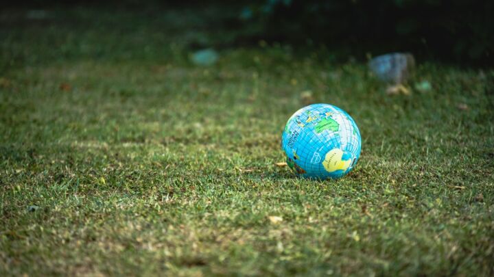 blue and white desk globe on green grass field during daytime