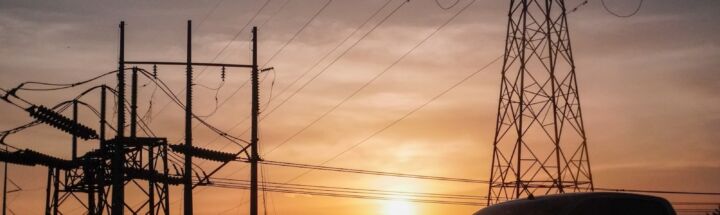 a car is parked in front of power lines at sunset