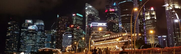 people walking on bridge over body of water during nighttime
