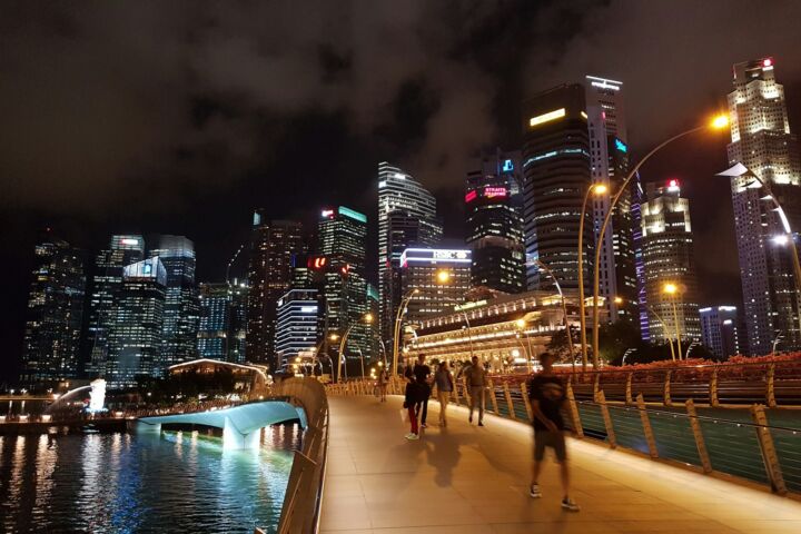 people walking on bridge over body of water during nighttime