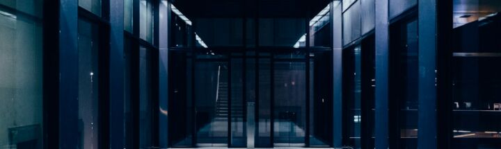 a long hallway with glass doors leading to another room