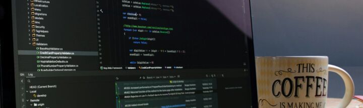 Laptop screen displaying code with a coffee mug.