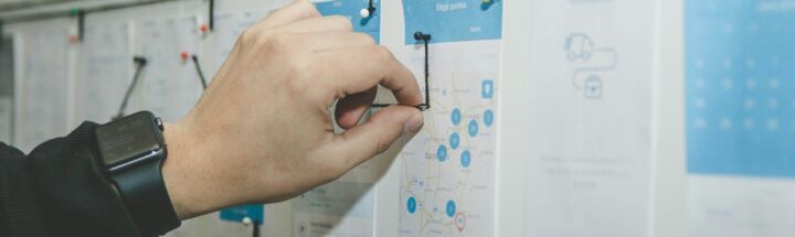 person working on blue and white paper on board