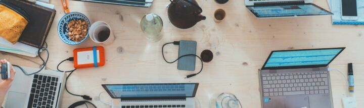 people sitting down near table with assorted laptop computers