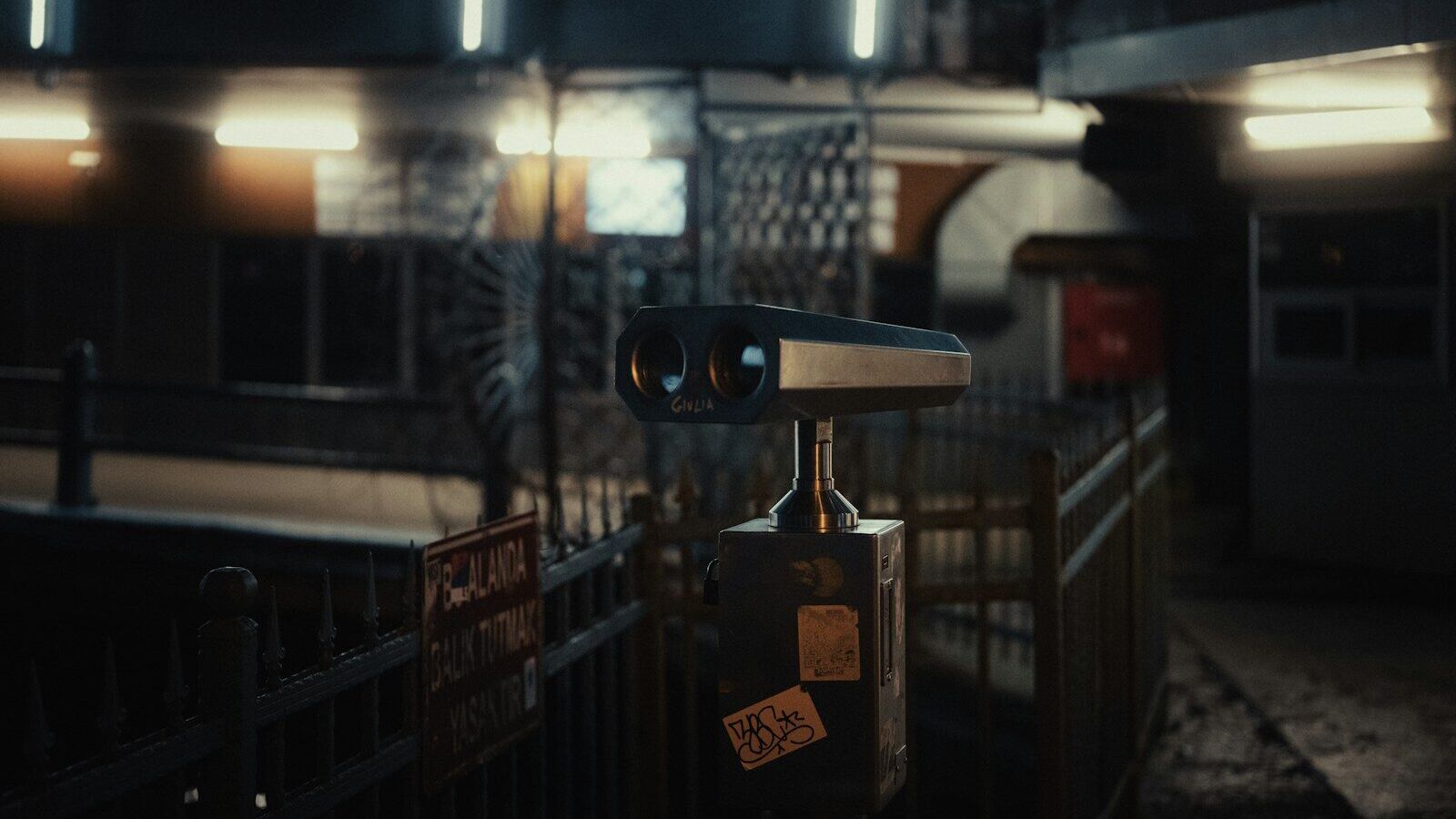 a pair of binoculars sitting on top of a metal fence