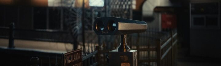 a pair of binoculars sitting on top of a metal fence