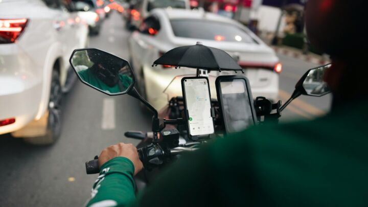 a man riding a motorcycle down a street next to traffic
