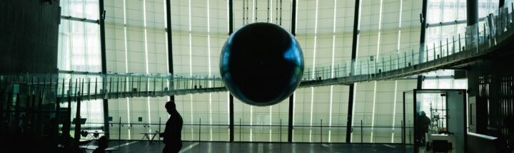 man in black jacket walking on gray floor