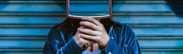 man covering face with mirror