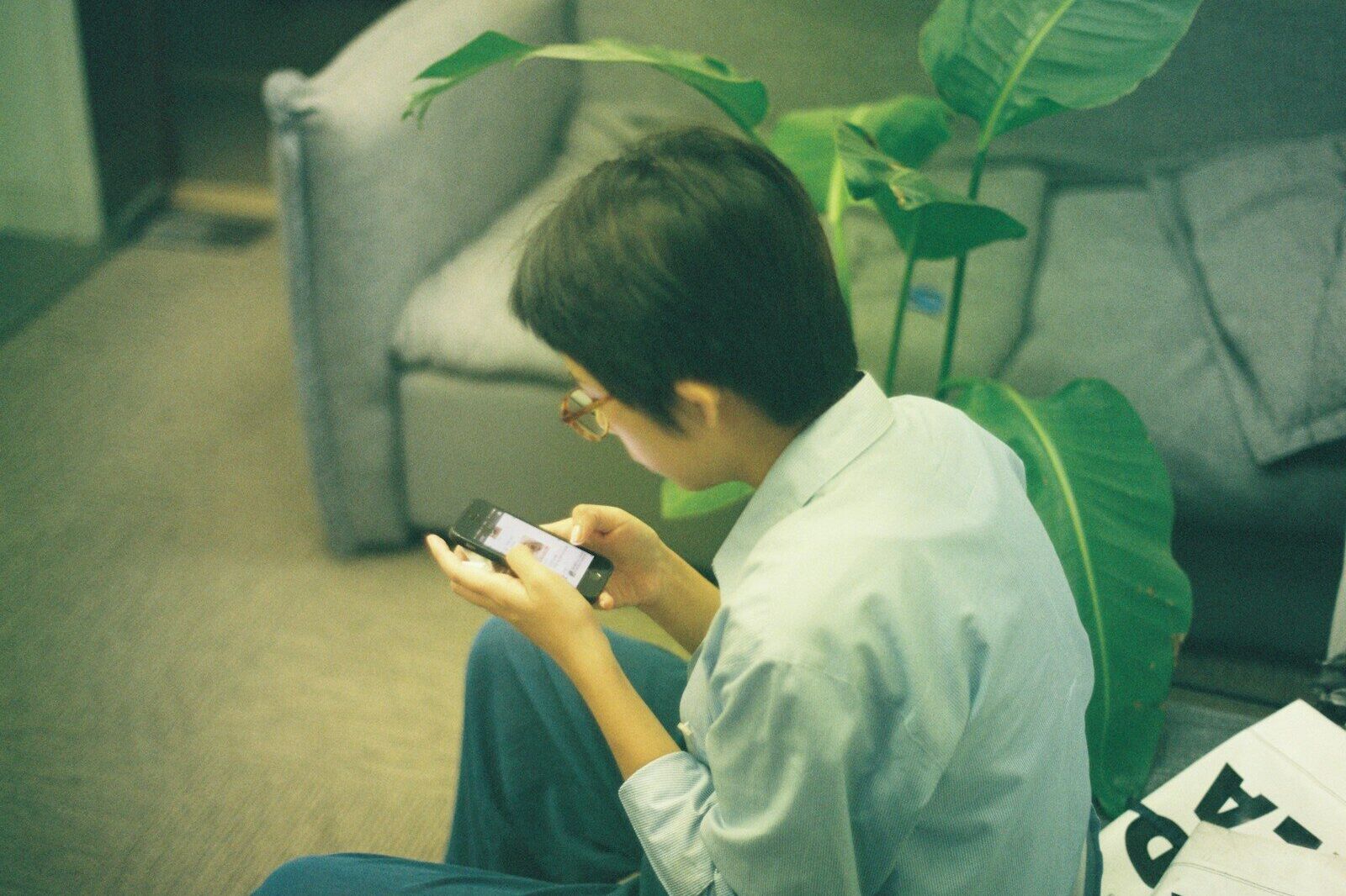 Person using a smartphone while sitting on the floor.