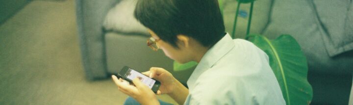 Person using a smartphone while sitting on the floor.