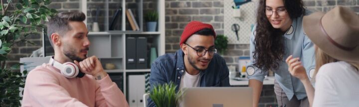 a group of people sitting around a wooden table