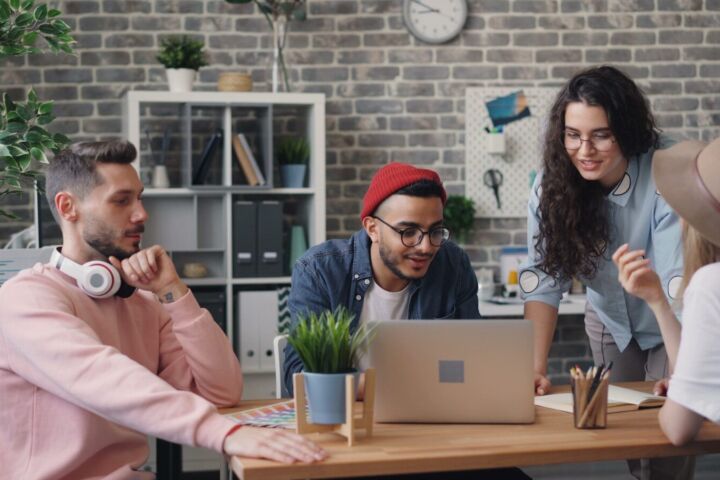 a group of people sitting around a wooden table