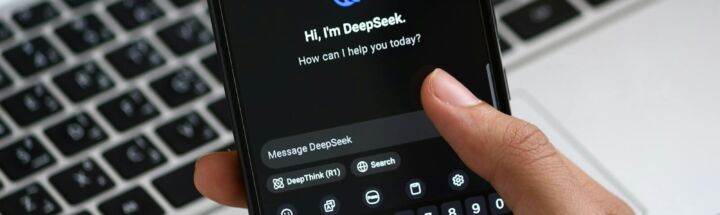 Person interacting with DeepSeek AI chat app on smartphone, focusing on digital innovation and communication.