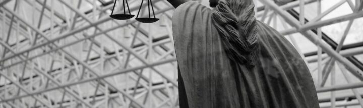 Statue of lady justice holding scales indoors