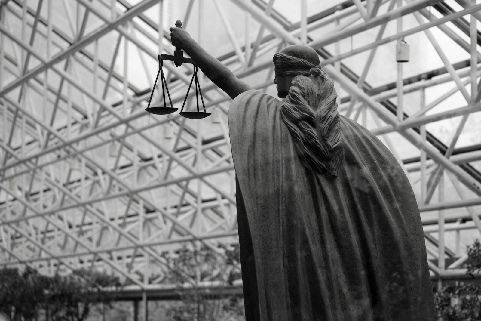 Statue of lady justice holding scales indoors