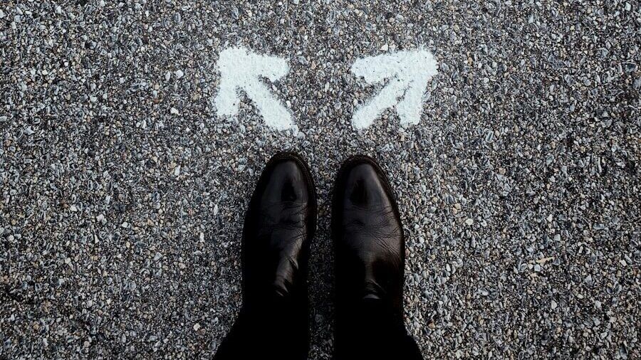 feet on asphalt between two directional arrows