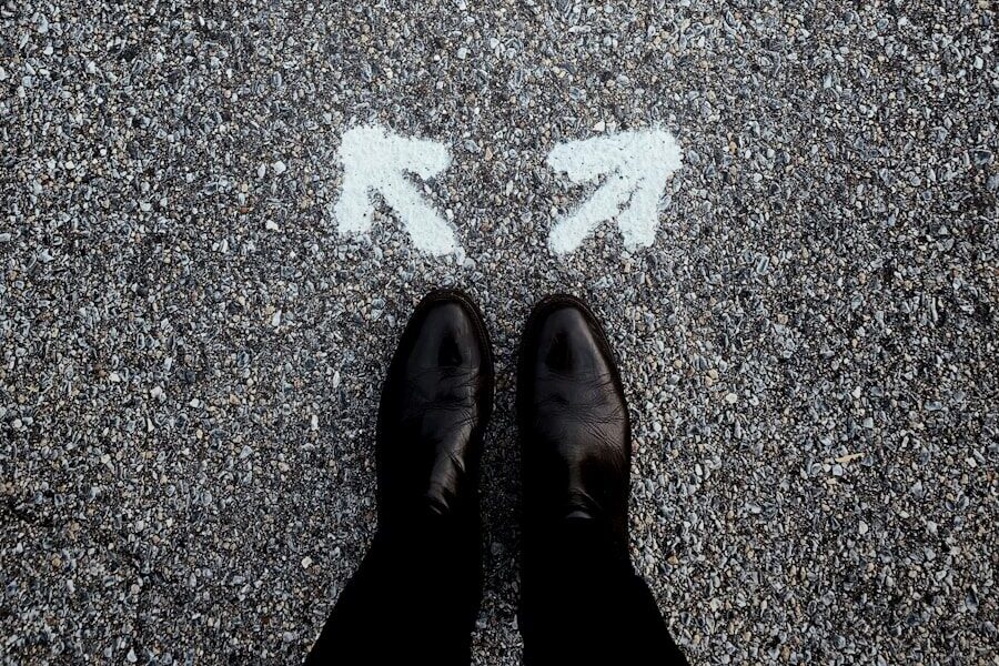 feet on asphalt between two directional arrows