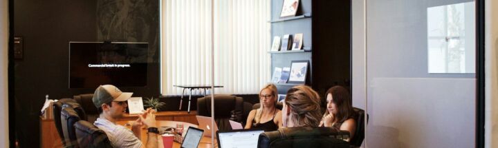 people sitting near table with laptop computer