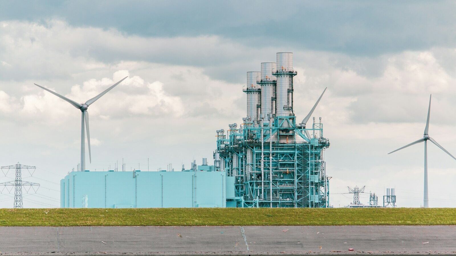 white and blue factory under white clouds during daytime