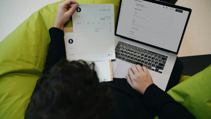 A person sitting on a bean bag chair working on a laptop