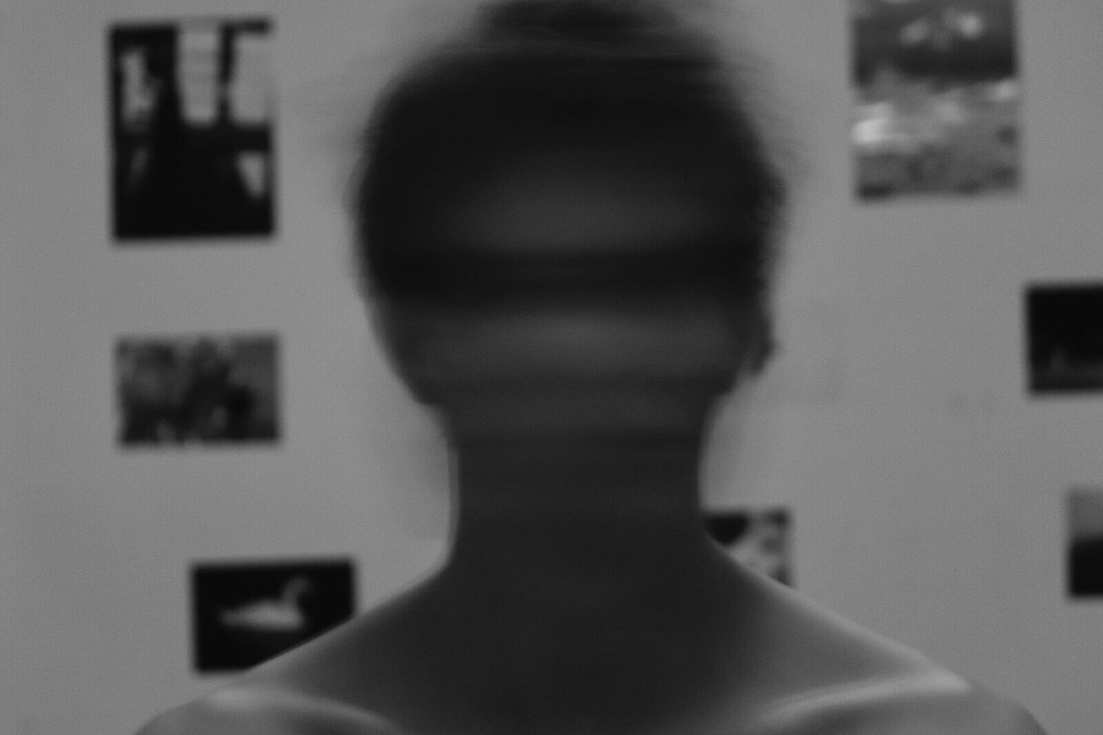 a blurry image of a man's face in front of a wall with