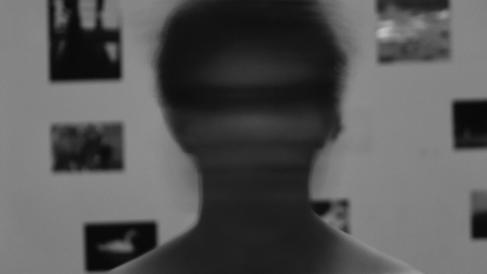 a blurry image of a man's face in front of a wall with