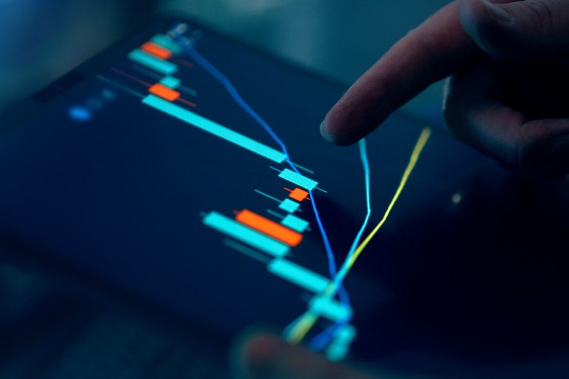 Fingers interacting with a stock market graph on a tablet