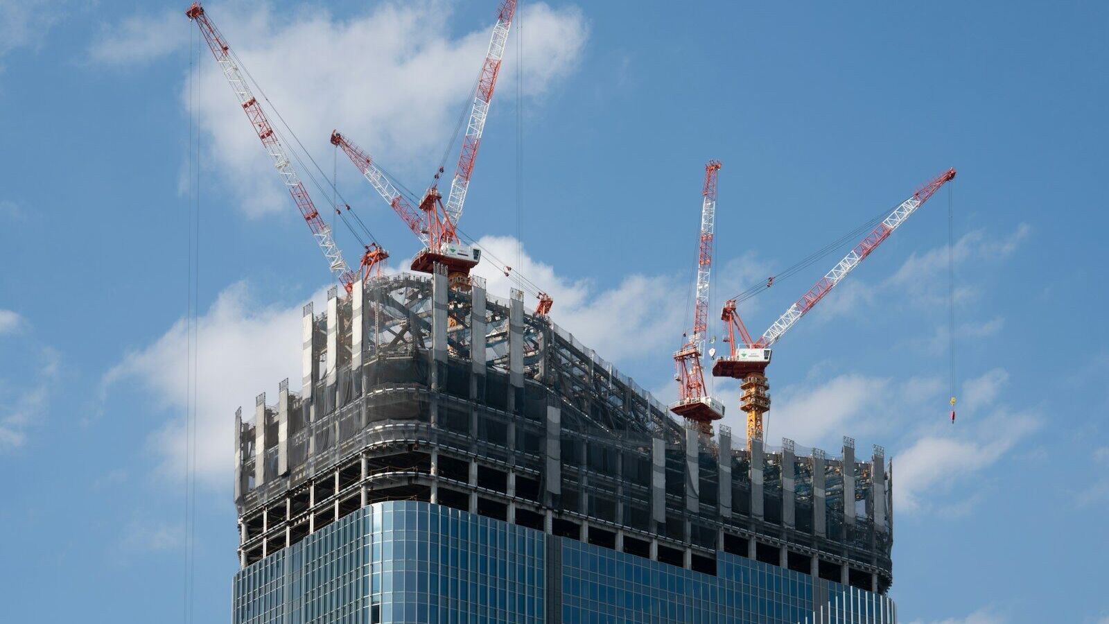 a tall building with cranes on top of it