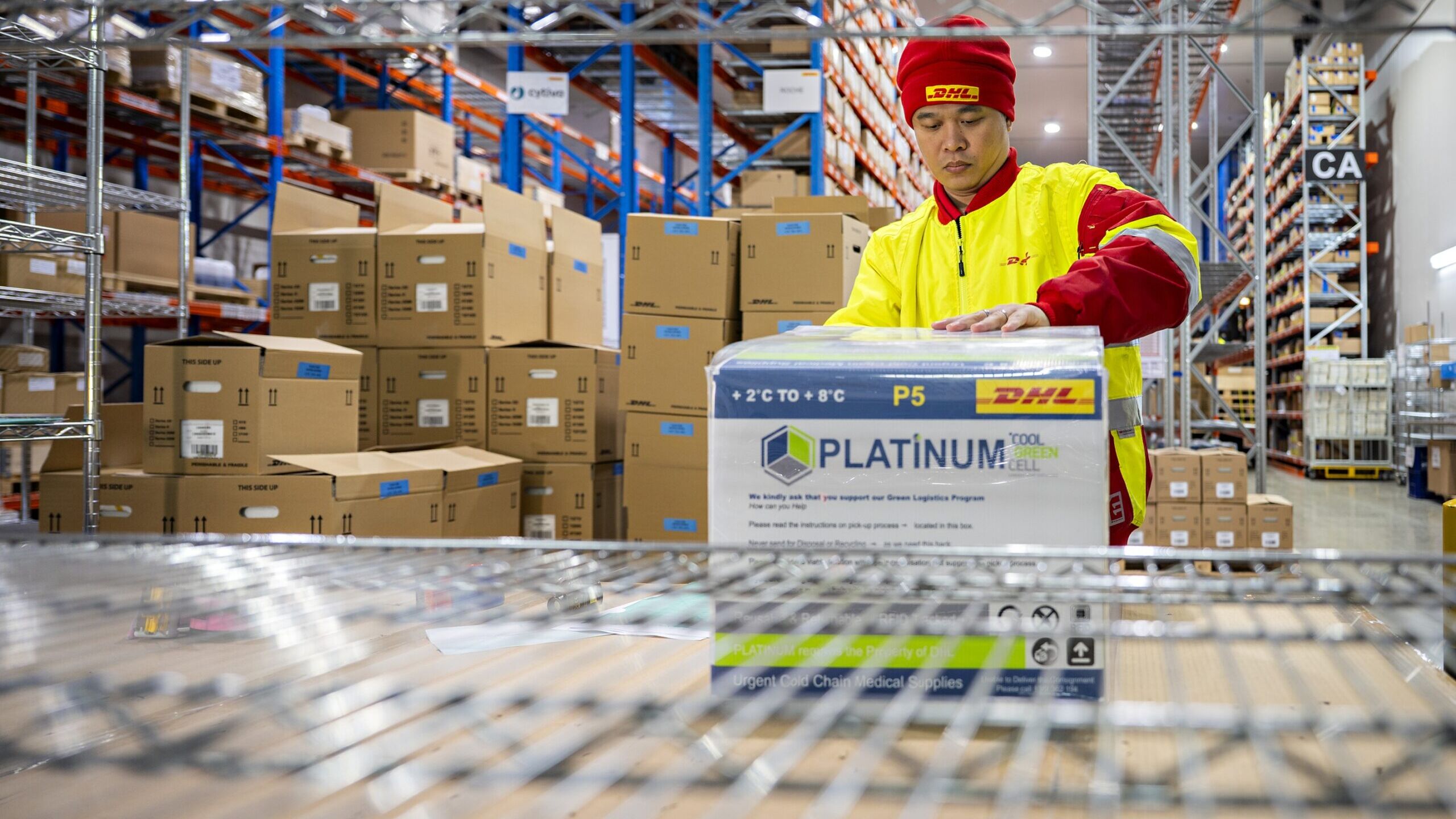 A DHL worker handles a temperature-controlled medical shipment at a pharmaceutical warehouse in Singapore