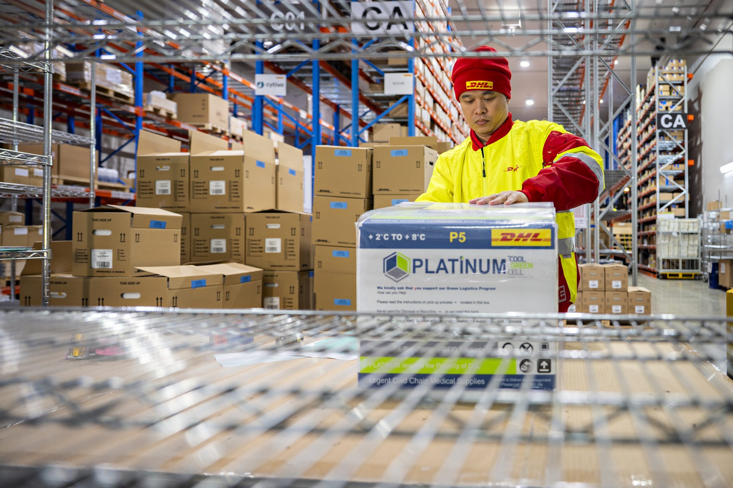 A DHL worker handles a temperature-controlled medical shipment at a pharmaceutical warehouse in Singapore