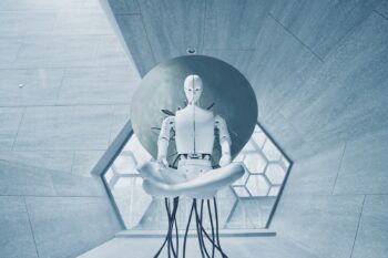 A white humanoid robot in a lotus position against a large circular disc
