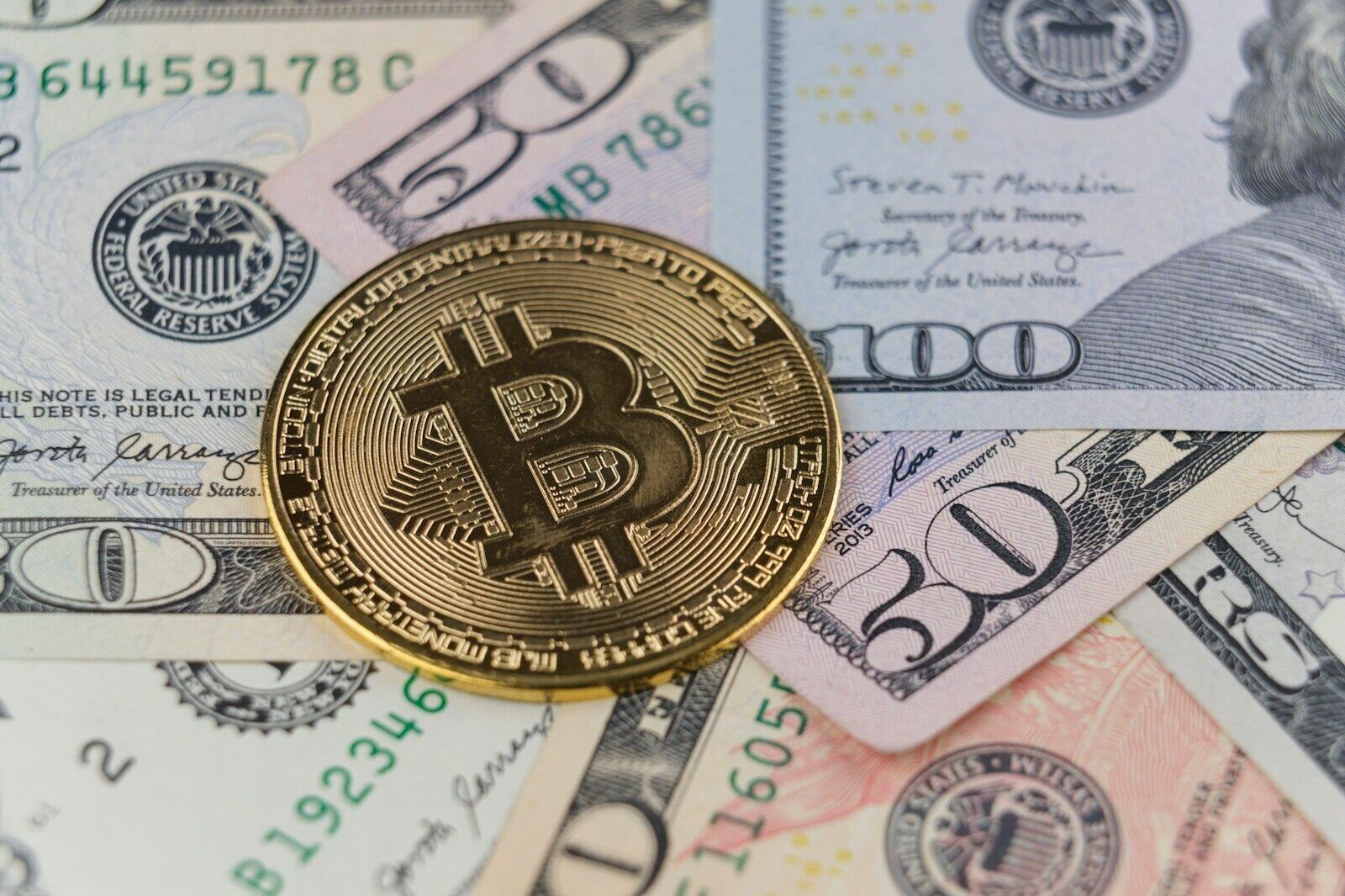 a bitcoin sitting on top of a pile of money