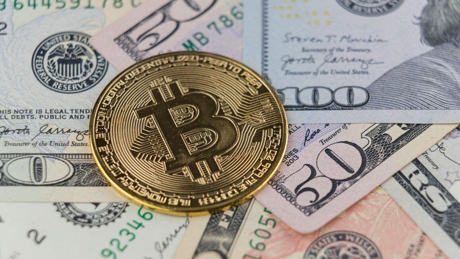a bitcoin sitting on top of a pile of money
